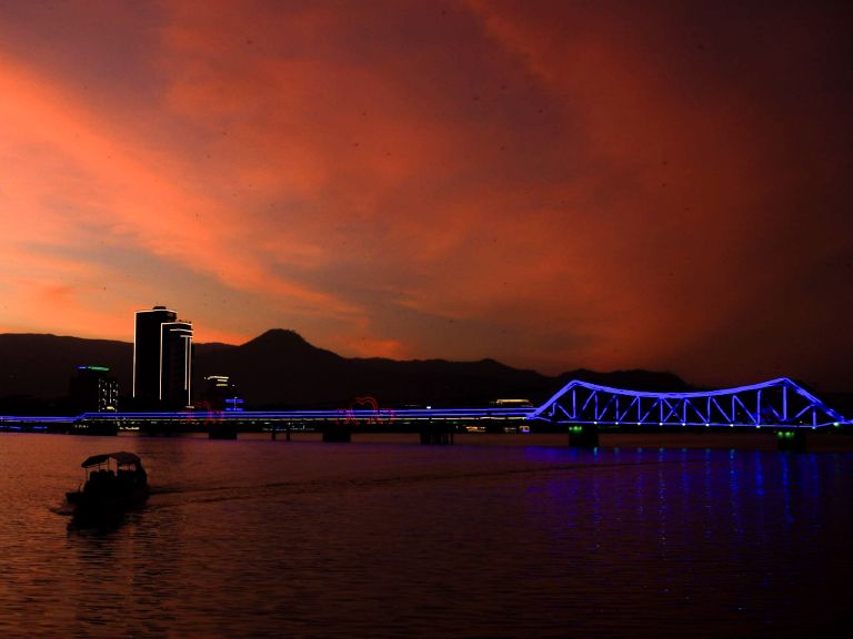 Sunset over the Kampot river with a boat silhouette